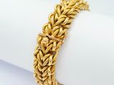 a close up of a gold bracelet on a napkin