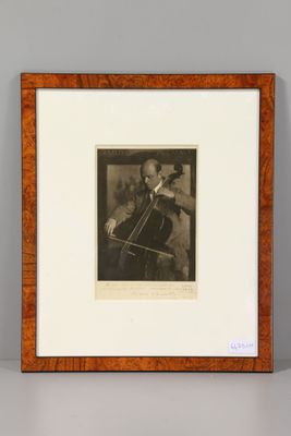 a black and white photo of a man playing a cello