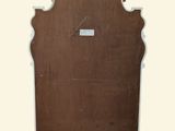 a wooden mirror with a white frame on the wall