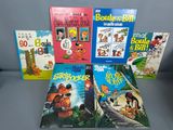 several children ' s books are lined up in a row on a table