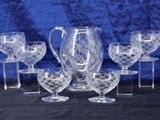 a group of glasses and a pitcher on a table