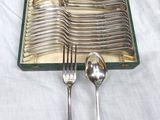 a lot of silver spoons and forks in a case