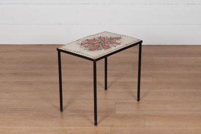 une petite table avec un plateau en carrelage posée sur un plancher en bois