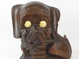 une statue en bois représentant un chien aux yeux jaunes