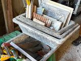 un homme debout à côté d'un chariot rempli d'outils