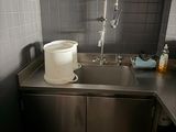 a sink in the corner of a kitchen with a faucet in it