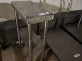 trois tables en acier inoxydable dans une pièce au sol carrelé