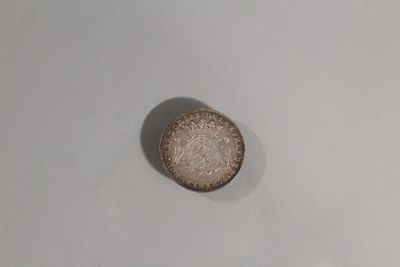 une pièce d'argent posée sur une table blanche