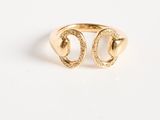 a gold plated ring with two horseshoes and diamonds