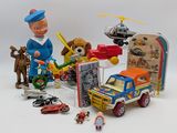 a small toy truck with a toy car and a toy helicopter