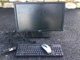 a computer monitor, keyboard and mouse on the ground