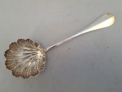une cuillère en argent ornée d'une feuille, posée sur une table