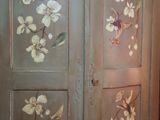 a cabinet that has been painted with flowers on it