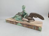 bronze statue of a boy and a bird on a wooden base