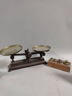 une balance sur laquelle se trouvent deux boîtes de pièces