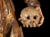 statue of a woman holding a skull in her hand