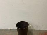 a black pot sitting on the floor next to a white wall