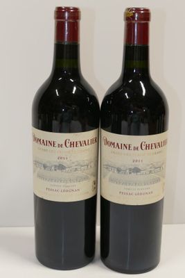 deux bouteilles de vin posées sur une table l'une à côté de l'autre