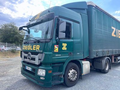 un camion vert garé sur un parking