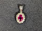 un gros plan d'un pendentif orné d'un diamant rose et blanc sur une surface noire