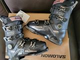 deux paires de chaussures de ski posées sur une boîte en carton