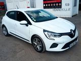 La voiture blanche est garée devant une station-service.