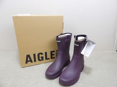 pair of purple rain boots sitting in front of a box