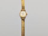 a gold watch with a white face and a black strap