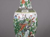 a vase that has a bird on it on a stand