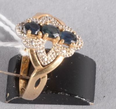 une bague en or sertie de pierres bleues et blanches