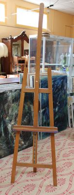 a wooden easel with a painting on it in a room