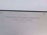 the back of a silver laptop computer sitting on top of a table