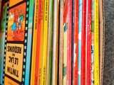 a box full of children ' s books sitting on the floor