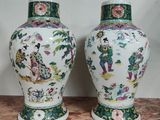 une paire de vases chinois posés sur une table en marbre, avec un mur en arrière-plan