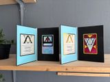 several cards are lined up on a shelf next to a potted plant
