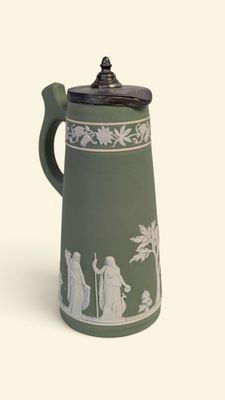 une cafetière verte et blanche avec un couvercle noir
