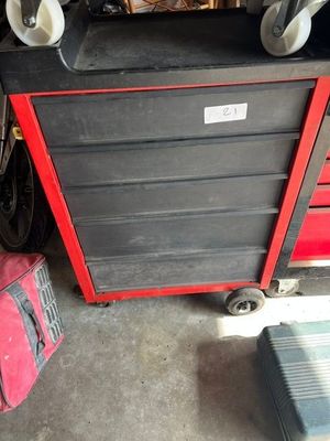 une boîte à outils rouge et noire à roulettes et une valise rouge