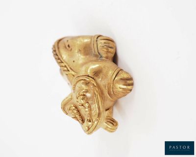 a gold figurine on a white surface with a white background