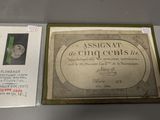 une vieille assiette en argent sur laquelle figurent les portraits d'un homme et d'une femme