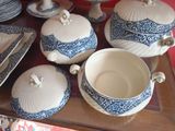 many plates and bowls on the table with blue and white designs