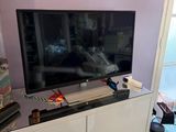 a flat screen tv sitting on top of a white cabinet