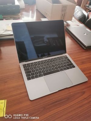 a laptop computer sitting on a wooden table