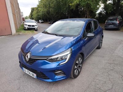 La voiture bleue est garée sur le parking, près des arbres.
