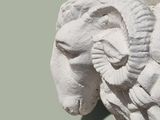 a white statue of a ram with horns on it ' s head