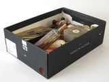 a black box filled with assorted items on a white surface