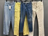 trois paires de jeans suspendues à un portant