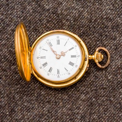 une montre de poche en or avec des chiffres romains