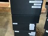 three black boxes are stacked on top of each other in a warehouse