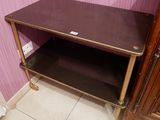 une petite table avec une étagère, dans un coin de la pièce