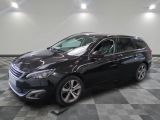 la voiture noire est garée sur un sol en damier dans le garage